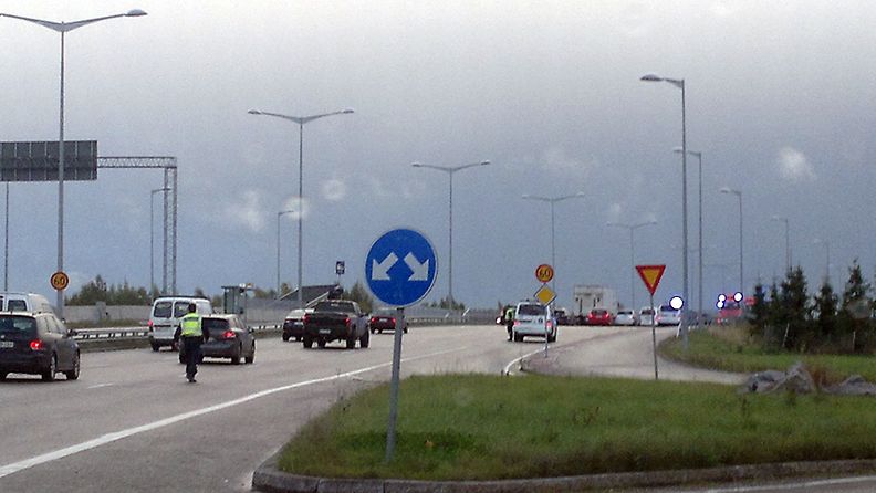 Poliisit ohjaavat liikennettä kolmen auton ketjukolarin jäljiltä Hakamäentiellä Pasilassa. 