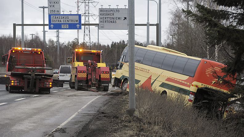 Tieltä suistunutta linja-autoa nostetaan penkasta Itäväylällä Helsingissä 14. huhtikuuta 2012.