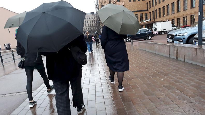 Ihmiset kävelevät sateessa Postitalon edustalla Helsingissä 26. huhtikuuta 2010.