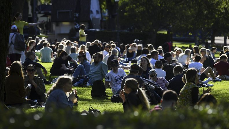 Kouluvuoden päätöksen juhlintaa kauniissa auringonpaisteessa Esplanadin puistossa Helsingissä alkuillasta 