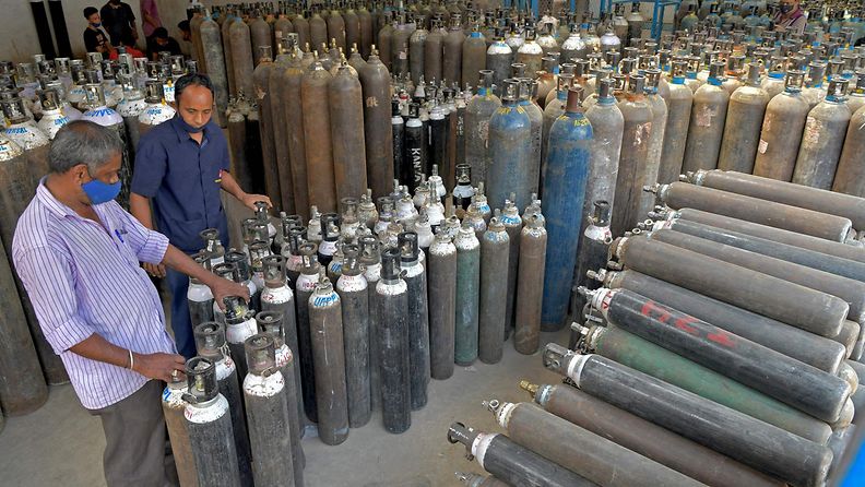 Workers are seen sorting oxygen cylinders that are being used for Covid-19 coronavirus patients before dispatching them to hospitals at a facility in Bangalore on April 19, 2021. 
