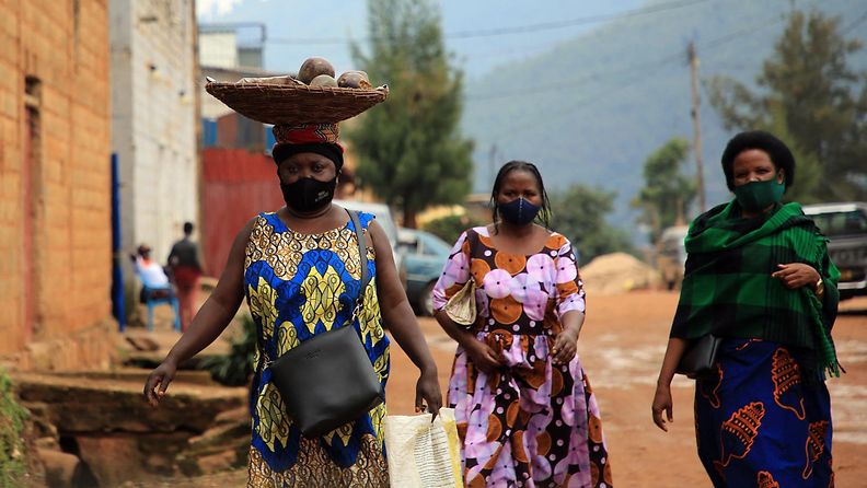 Naisia kävelemässä pukeutuneina värikkäisiin mekkoihin ja kasvomaskeihin Ruandan pääkaupungissa Kigalissa huhtikuussa 2021.