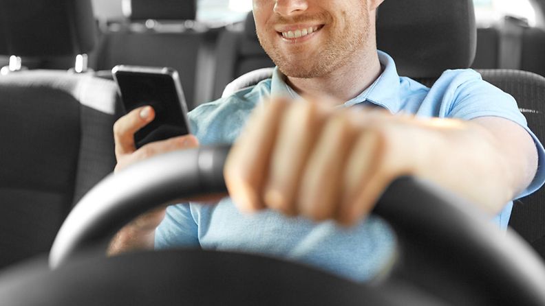 shutterstock auton ajaminen kännykkä kädessä