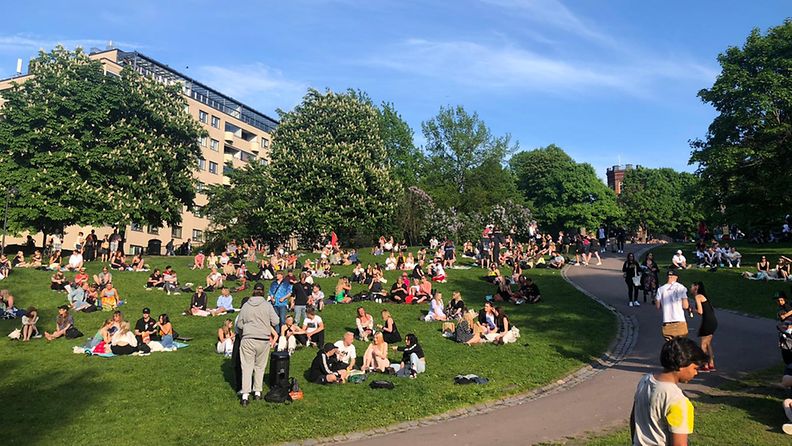 Ihmisiä viettämässä kesäpäivää ja koulujen päättäjäisiä Helsingissä Sinebrychoffin puistossa 5. kesäkuusta 2021. 