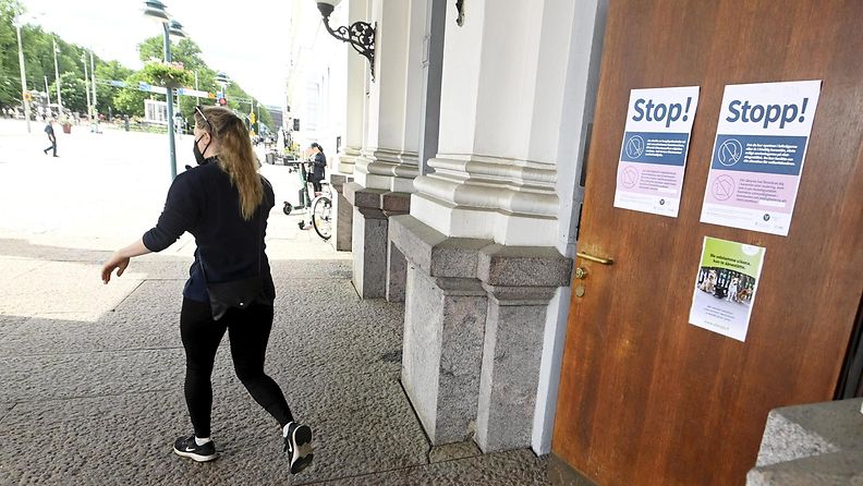 Tummiin pukeutunut nainen lähtee äänestyspaikalta Helsingin kaupungintalolta vaalipäivänä 13. kesäkuuta. 