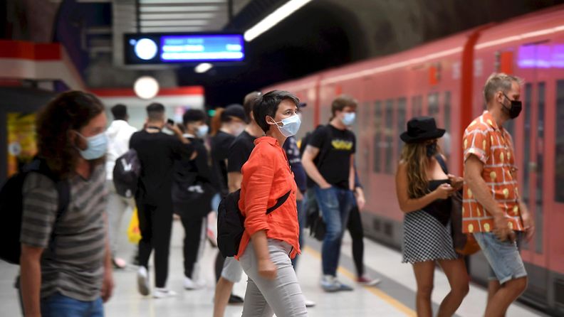 Ihmiset talsivat metroon maskit kasvoillaan.