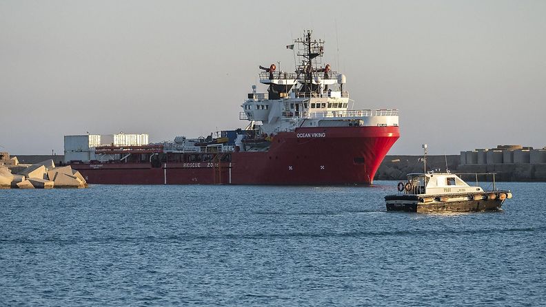 Siirtolaisia sisältävä punarunkoinen laiva seisoo satamassa Sisilian lähellä.