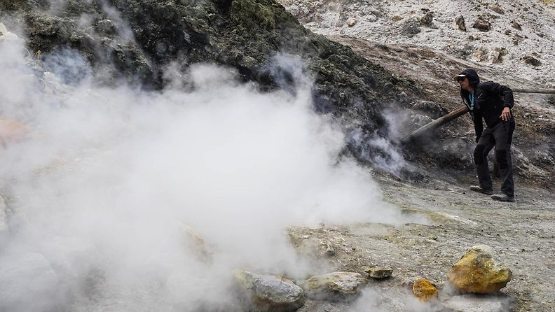 Turisti katsoo vierestä, kun kaasua nousee Campi Flegrein tulivuoren kraaterista.
