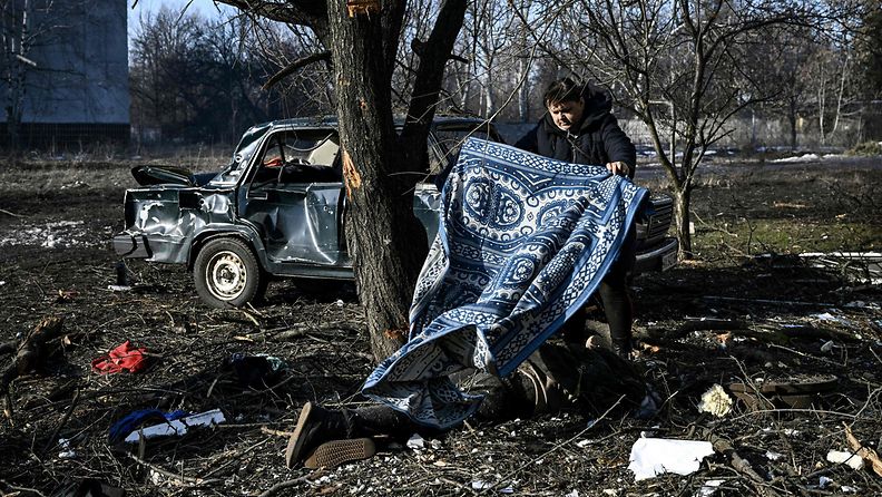 Mies peitteli pommituksessa menehtynyttä Tšuhujivissa, Harkovan alueella Itä-Ukrainassa 24. helmikuuta.