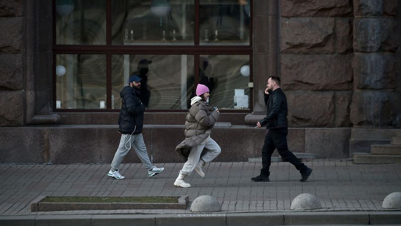 Nainen juoksee hälytyssireenin soidessa Kiovassa.