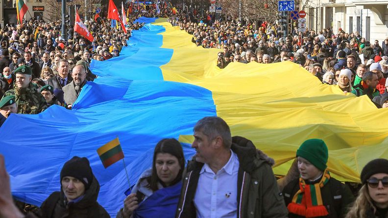 LK 11.3.2022 Ihmiset protestoivat Venäjän hyökkäystä Ukrainaan jättimäisen Ukrainan lipun kanssa Vilnassa Liettuassa tänään 11.3.2022.