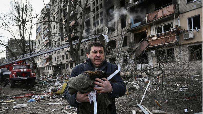 Mies seisoo Kiovassa kuolleen kissansa kanssa rakennuksen edessä, johon raporttien mukaan tehtiin ohjusisku 14. päivä maaliskuuta.