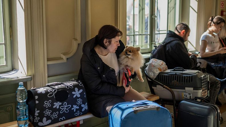 LK 28032022 Ukrainalainen pakolainen istuu koira sylissään Przemyślin rautatieasemalla Kaakkois-Puolassa lähellä Ukrainan rajaa 28.3.2022.