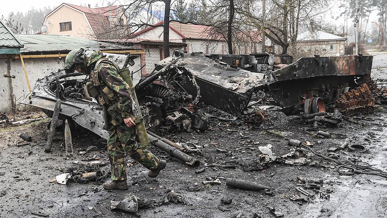 Ukrainalainen sotilas tuhoutuneiden panssariajoneuvojen lähellä huhtikuun 1. päivänä Irpinissä.