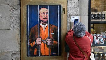 Italialaisen katutaitelijan maalaama kuva Vladimir Putinista, jossa hän on telkien takana.