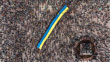 LK 18.4.2022 Vapaa Ukraina, Vapaa maailma -mielenosoitustilaisuuteen osallistuneet ihmiset kannattelevat Ukrainan lippua Senaatintorilla.
