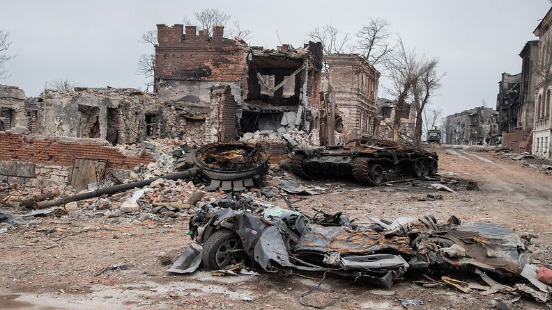 Tuhoutunut tankki ja raunioituneita rakennuksia Ukrainassa huhtikuussa 2022.