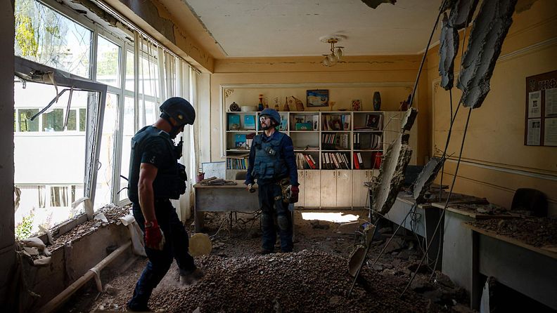 Ukrainan miinanraivausryhmän jäsenet etsivät räjähtämättömiä miinoja koulurakennuksessa venäläisten pommitusten jälkeen Hrkovassda Itä-Ukrainassa 28.4.2022.
