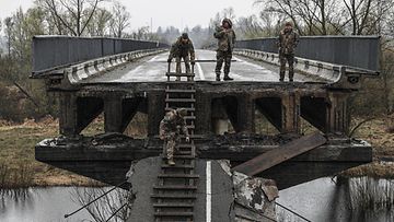 Ukrainalaissotilaat tutkivat vaurioitunutta siltaa Teterivin joella Borodjankassa, Kiovan lähistöllä, 22. huhtikuuta.