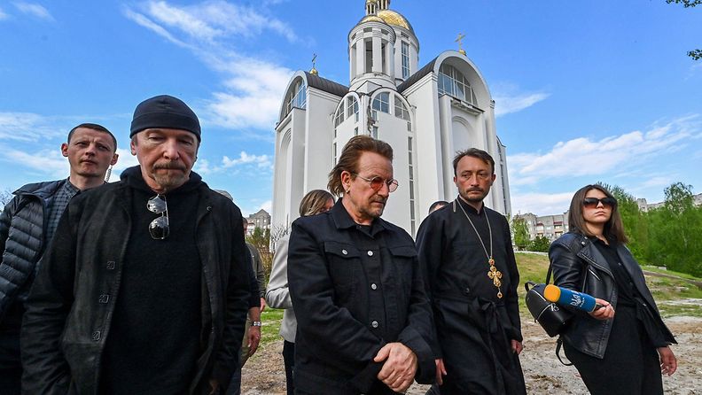 Pastori Andrii Holovine sekä U2-yhtyeen jäsenet Bono ja The Edge vierailevat joukkohaudalla Butshassa.