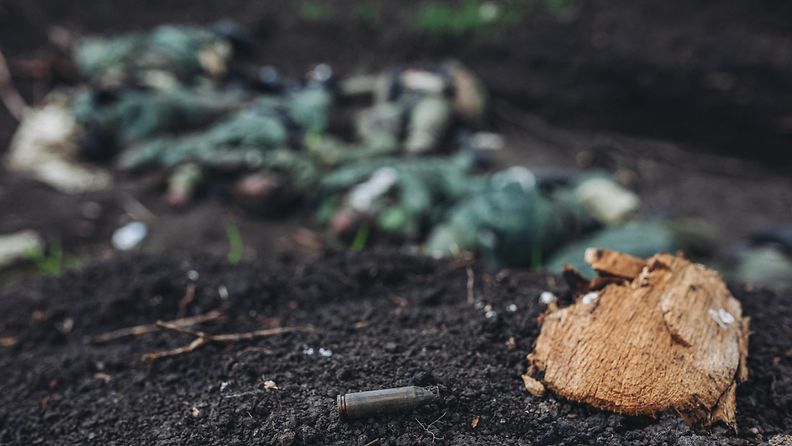 Luoti maassa Harkovan lähistöllä Ukrainassa. Taustalla näkyy sumeana venäläissotilaiden ruumiita.