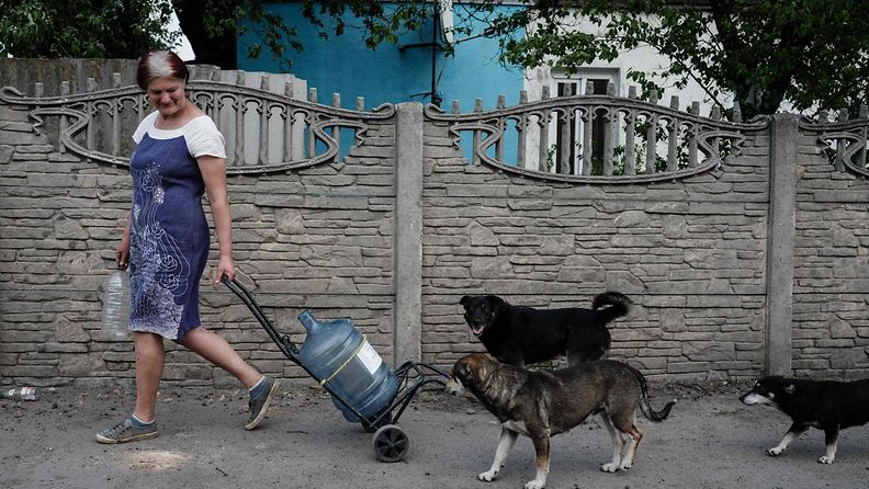 LK 14.5.2022 Nainen kantoi vettä koirat seuranaan Lysytšanskissa Itä-Ukrainassa eilen 13.5.2022.