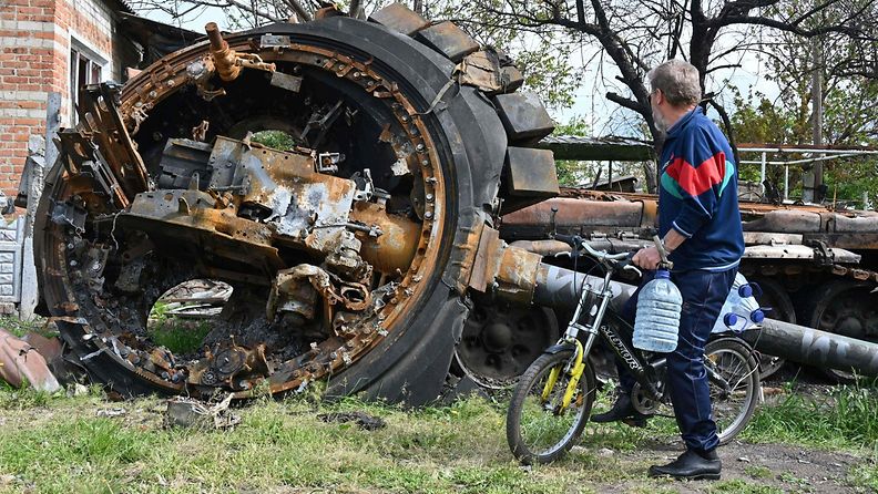 Paikallinen mies katseli tuhoutunutta venäläistankkia asuinrakennuksen vierellä Mala Rogan kylässä Harkovan itäpuolella 15. toukokuuta.
