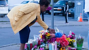 Nainen jätti kukkia Buffalon ammuskelussa kuolleiden muistoksi sunnuntaina.