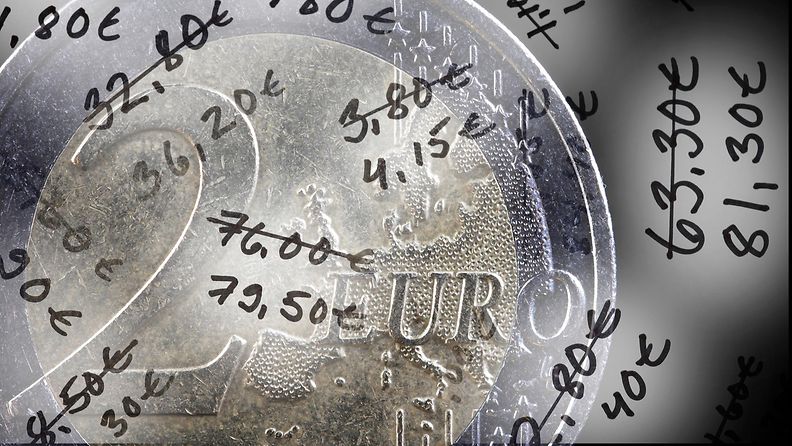 Kahden euron kolikko ja merkintöjä nousevista hinnoista.