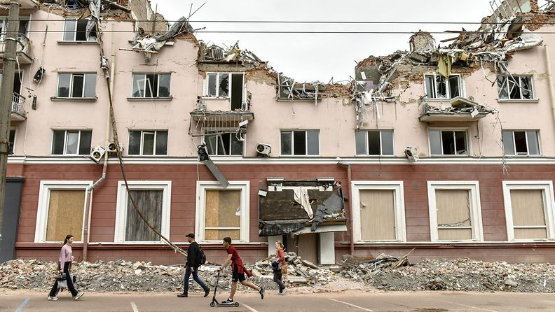 Ihmisiä kulki Venäjän ilmaiskussa tuhoutuneen hotellin raunioiden ohi Tshernihivissä 23. kesäkuuta.