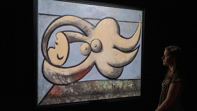 Vierailija katselee Picasson "Nainen makoilee" -taidemaalausta.