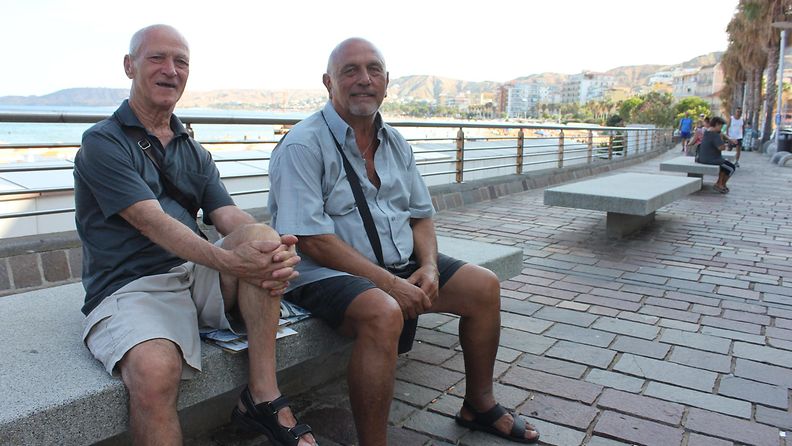 Eläkeläiset Francesco Carvelli (vas.) ja Rino Nicotera viettävät kesäpäivää Crotonen rantabulevardilla Italiassa 30. elokuuta 2022.