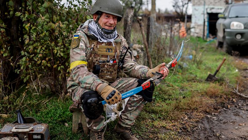 Ukrainan sotilas esitteli löytämäänsä käsijousta etsiessään räjähteitä Ukrainan vapauttamalta alueelta Hersonissa.