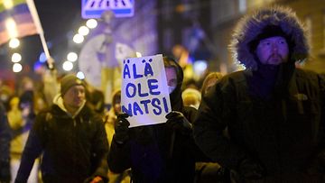 Mielenosoittaja pitää kylttiä, jossa lukee: "Älä ole natsi".