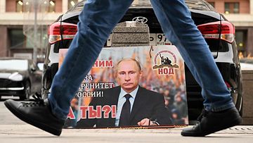 LK 3.2.2023: Kuvituskuvassa Venäjän presidentin Vladimir Putinin kuvalla varustettu plakaatti, jossa lukee "Olemme hänen puolellaan Venäjän suvereniteetin puolesta". Entä te?". Kuva on otettu Moskovassa 24. helmikuuta 2022.