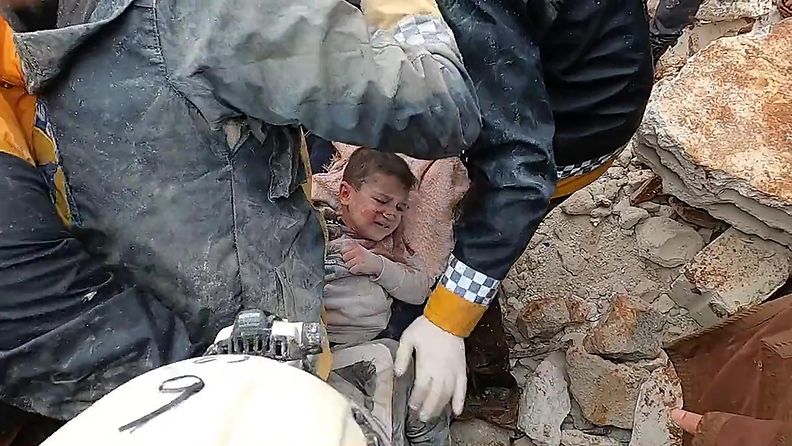 Lapsi pelastetaan raunioista Turkin maanjäristyksen jälkeen.