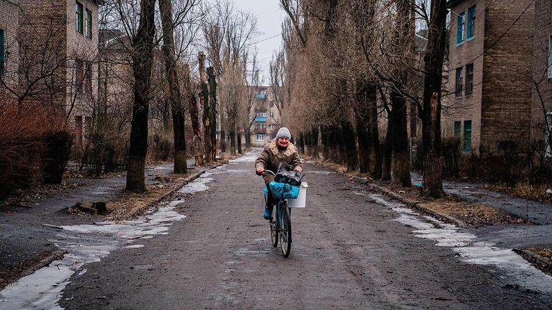 LK 2.3.2023 Nainen ajaa polkupyörällä tyhjällä kadulla Chasiv Yarissa, lähellä Bakhmutia 28. helmikuuta 2023, keskellä Venäjän sotilaallista hyökkäystä Ukrainaan.