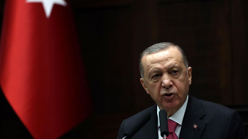 Turkin presidentti Erdogan maan lipun vieressä maaliskuussa 2023.
