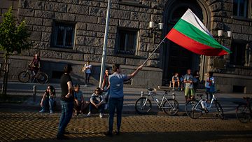 Bulgarian lippua heiluttava mielenosoittaja Bulgariassa heinäkuussa 2020.