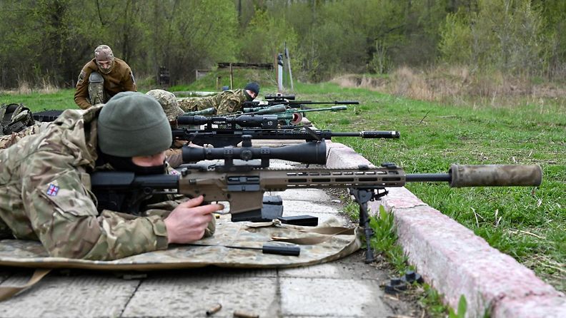 Harjoittelevat sotilaat makaavat tarkkuuskiväärit kourassaan ampuma-asennossa maaten.
