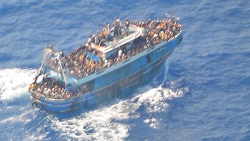 Vene pullollaan siirtolaisia keskellä merta.