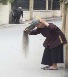 Vanhus harjaa hiuksiaan Hanoin kadulla.