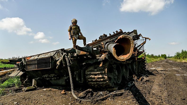 Ukrainan sotilas ja tuhoutunut taistelupanssarivaunu Zaporizhzhjan alueella.