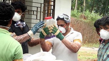 Kaivosta löydettyä lepakkoa tutkitaan Intian Keralan osavaltiossa. Kuva on vuodelta 2018.
