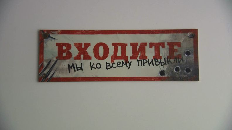 Venäjänkielinen kyltti, jossa lukee: Astu sisään, olemme tottuneet kaikkeen. 
