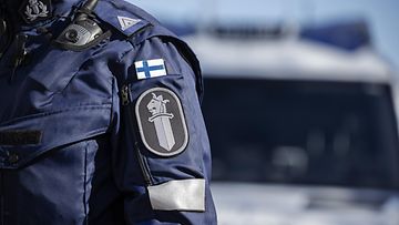 Poliisin logo ja Suomen lippu univormussa Oulun poliisilaitoksen järjestämässä mediatilaisuudessa Oulussa 12. huhtikuuta 2023.