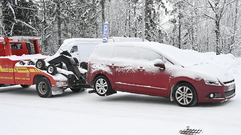 LK 6.1.2024  Lumen ja jään peittämää autoa hinataan Espoon Suvelassa torstaina 4. tammikuuta 2024. Viime päivien hirmupakkaset ovat näkyneet ruuhkina lämpimissä pysäköintihalleissa.