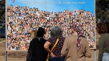 LK 7.2.2024 Ihmiset katsomassa julistetta, jossa on kuvia nuorista, jotka Hamasin militantit ovat ottaneet vangiksi tai tappaneet Supernova-musiikkifestivaalille osallistuneiden juhlijoiden kimppuun 7. lokakuuta 2023.