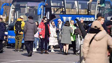 LK 9.2.2024 Ryhmä venäläisiä turisteja valmistautuu nousemaan linja-autoihin sen jälkeen, kun he ovat saapuneet Pjongjangin kansainväliselle lentokentälle Pjongjangissa 9. helmikuuta 2024.