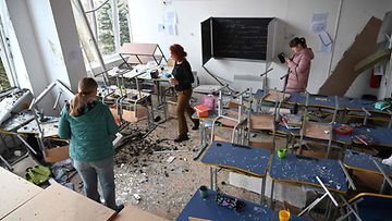 Koulun työntekijät tarkastavat luokkahuoneen vahinkoja ohjusiskujen jälkeen Lvivissä, Ukrainassa, 15. helmikuuta 2024.